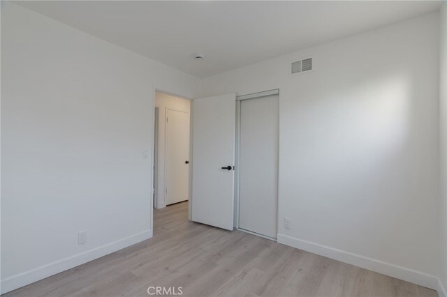 unfurnished bedroom featuring a closet and light hardwood / wood-style floors