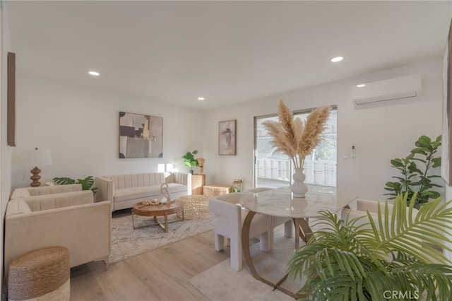 living room with light hardwood / wood-style flooring and a wall mounted air conditioner