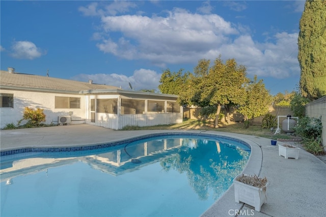 view of pool with a sunroom and a patio