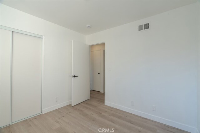 unfurnished bedroom featuring a closet and light hardwood / wood-style flooring