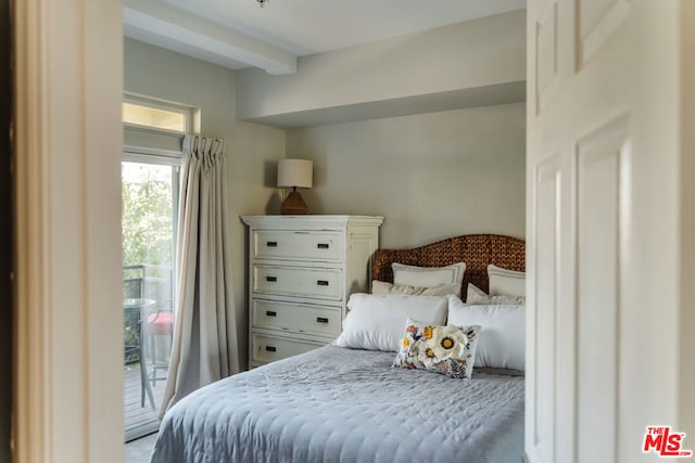 bedroom with access to outside and beamed ceiling