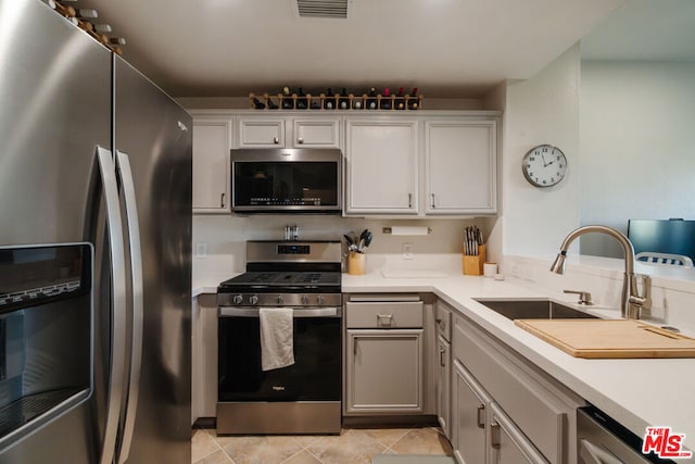 kitchen with light tile patterned floors, appliances with stainless steel finishes, and sink