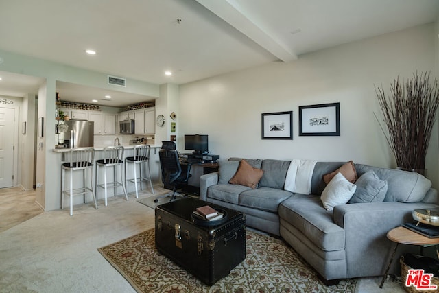 living room featuring light carpet and beamed ceiling