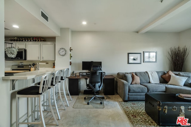 carpeted office featuring beam ceiling