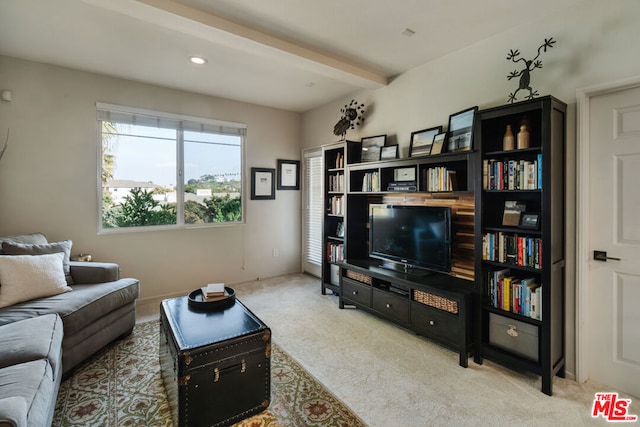 carpeted living room with beamed ceiling