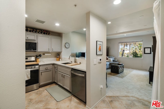 kitchen with light carpet, appliances with stainless steel finishes, gray cabinetry, and sink