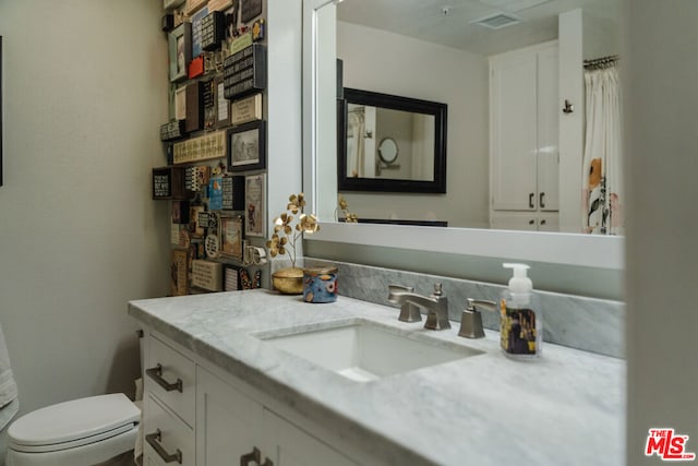 bathroom featuring toilet and vanity