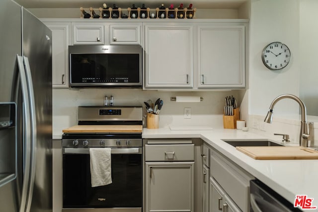 kitchen with white cabinets, appliances with stainless steel finishes, and sink