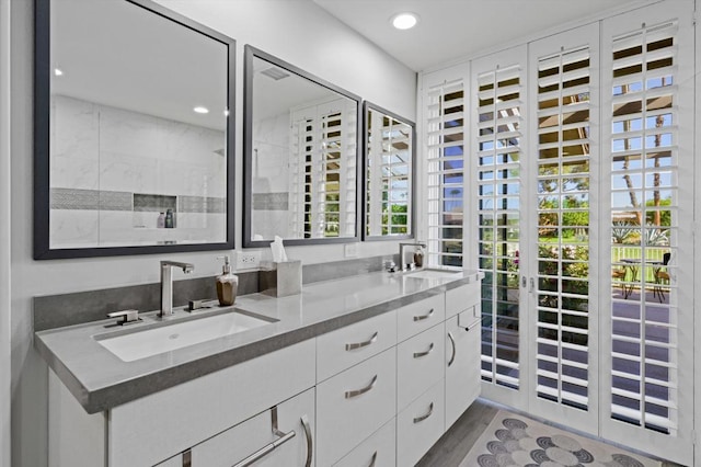 bathroom featuring walk in shower, hardwood / wood-style floors, and vanity