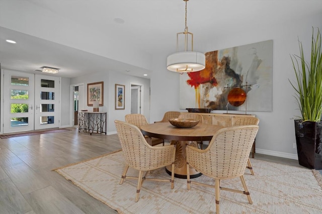 dining space with french doors and light hardwood / wood-style flooring