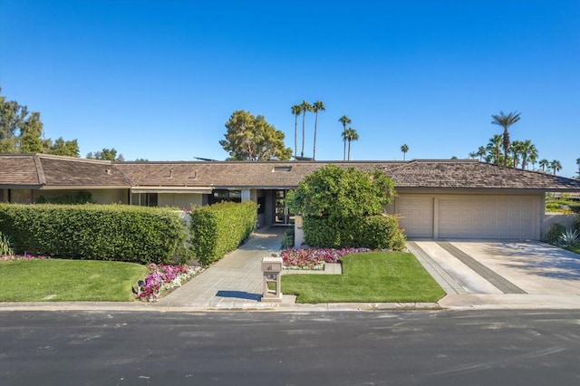 single story home featuring a garage and a front lawn