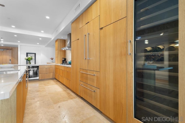 kitchen featuring gas cooktop, wall chimney exhaust hood, beverage cooler, wall oven, and light stone countertops