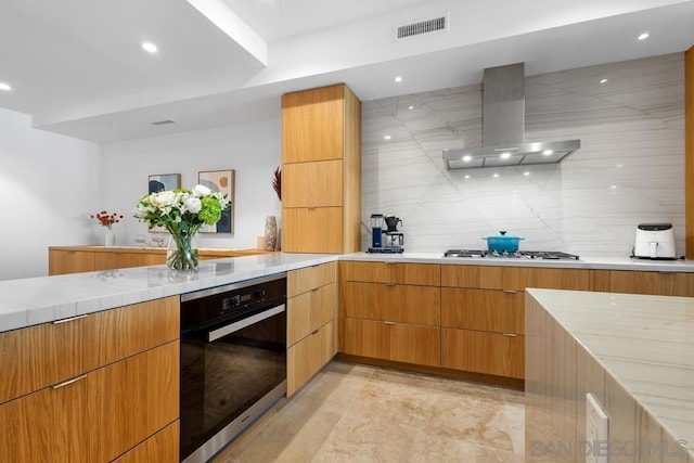 kitchen with tasteful backsplash, stainless steel appliances, and wall chimney exhaust hood