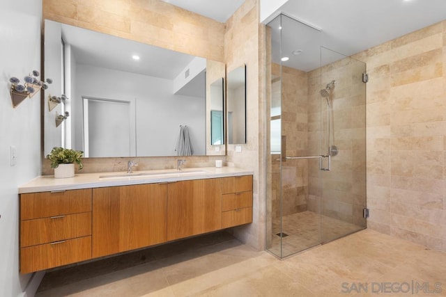 bathroom with a shower with door and vanity