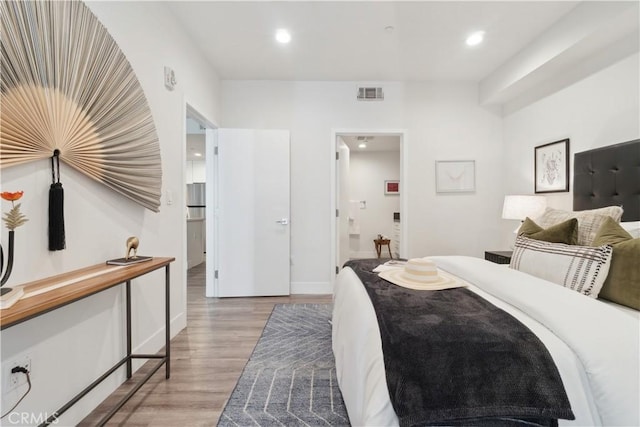 bedroom featuring light hardwood / wood-style floors and connected bathroom