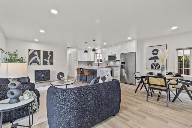 living room with light wood-type flooring and sink