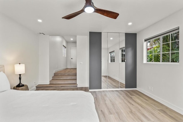 unfurnished bedroom with ceiling fan, a closet, and light hardwood / wood-style flooring