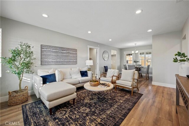 living room featuring light hardwood / wood-style floors and an inviting chandelier