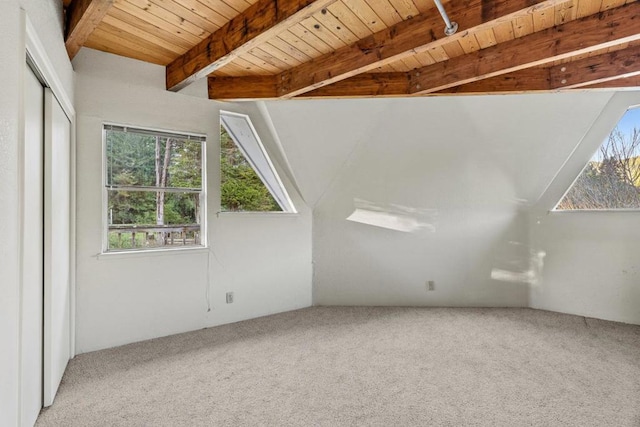 additional living space featuring carpet floors, vaulted ceiling with beams, and wood ceiling