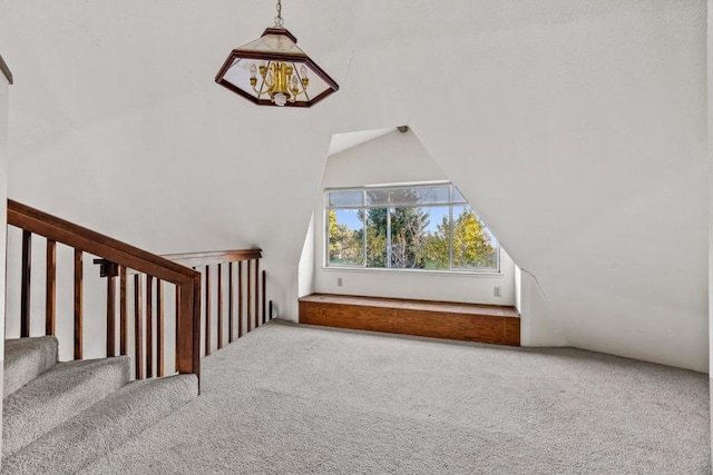 additional living space featuring carpet floors, a notable chandelier, and vaulted ceiling