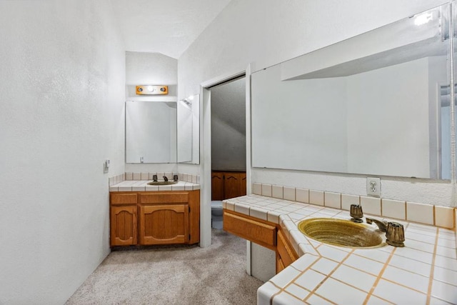 bathroom with vanity and vaulted ceiling