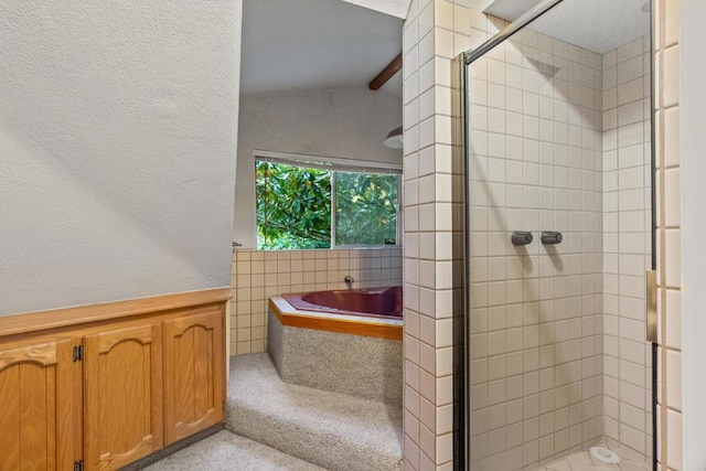 bathroom featuring lofted ceiling with beams and independent shower and bath