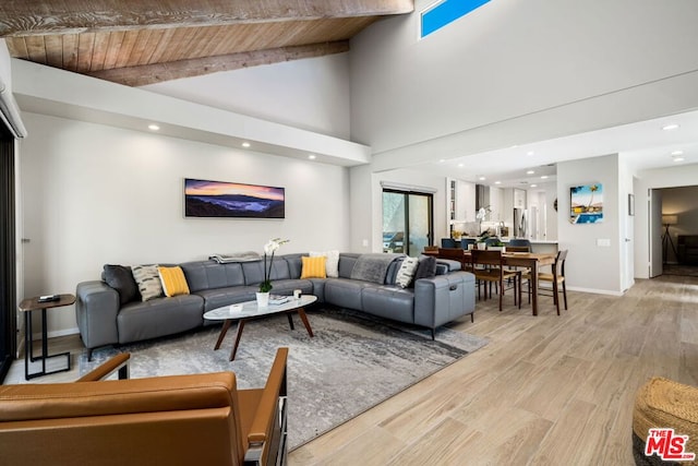 living room with high vaulted ceiling, wooden ceiling, and light hardwood / wood-style floors