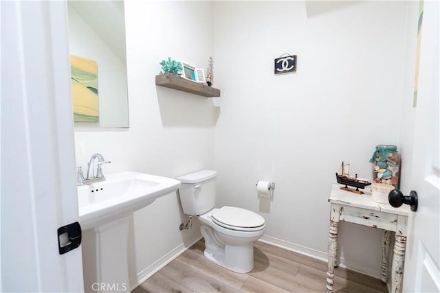 bathroom with hardwood / wood-style flooring, sink, and toilet