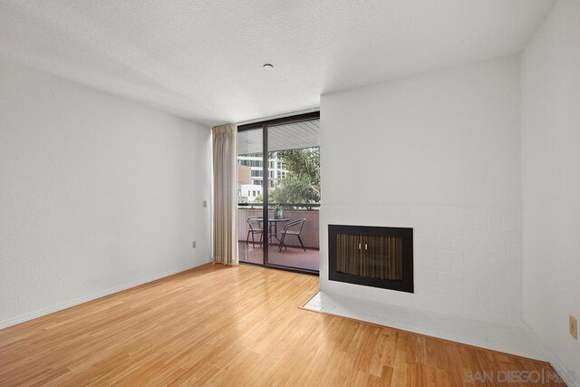 unfurnished living room featuring a textured ceiling, floor to ceiling windows, and wood-type flooring