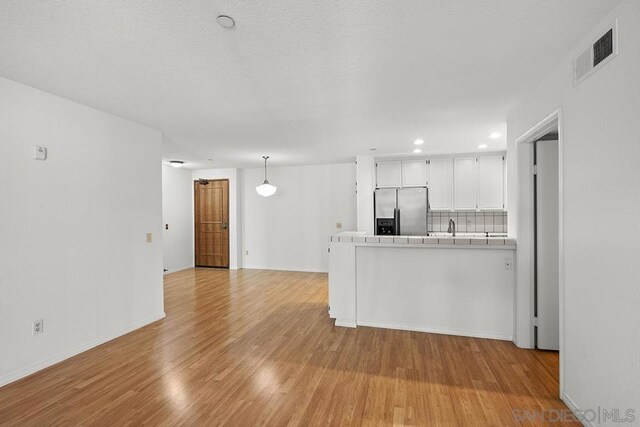 unfurnished living room featuring light hardwood / wood-style floors and sink