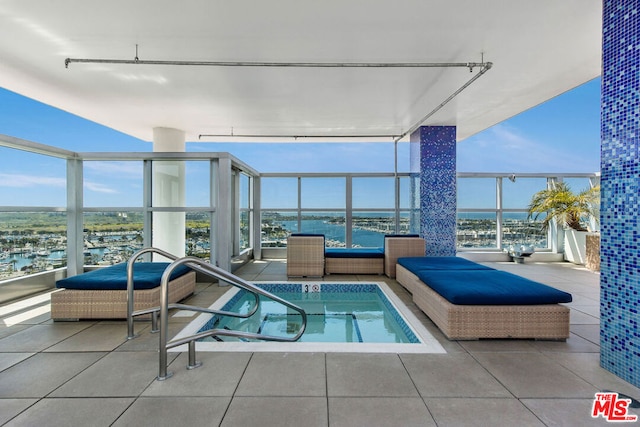 view of pool featuring a water view and an in ground hot tub