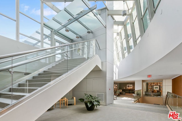 stairs featuring a high ceiling and carpet