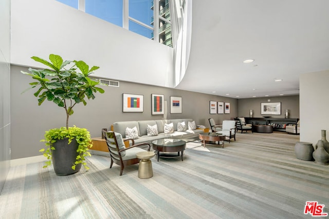 carpeted living room with a towering ceiling