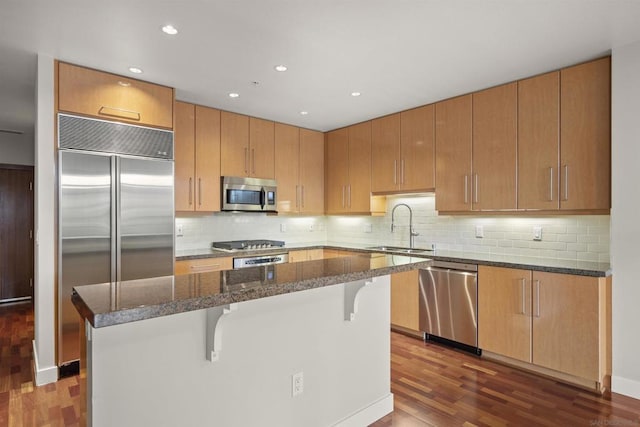 kitchen featuring sink, dark hardwood / wood-style floors, a center island, and stainless steel appliances