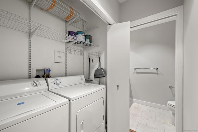 laundry area with light tile patterned floors and washer and clothes dryer