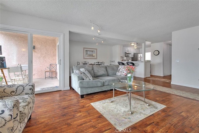 living room featuring a textured ceiling and dark hardwood / wood-style flooring