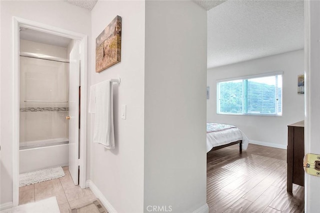 bathroom with a textured ceiling, enclosed tub / shower combo, and vanity