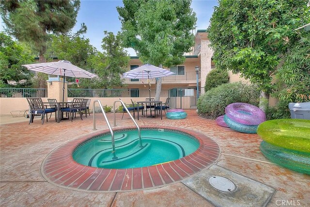 view of pool featuring an in ground hot tub and a patio