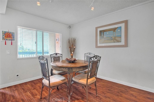 dining room with a textured ceiling and dark hardwood / wood-style flooring