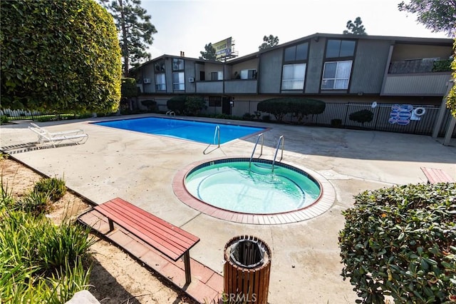 view of swimming pool featuring a patio area and a community hot tub