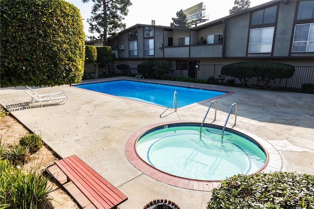 view of swimming pool with a patio area and a community hot tub