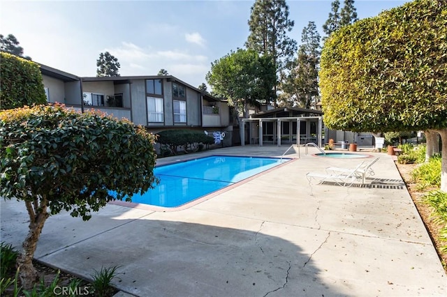 view of swimming pool featuring a patio area and a community hot tub