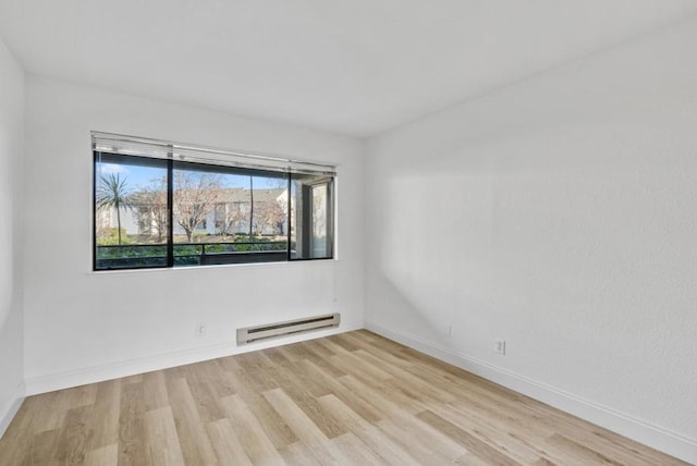 unfurnished room featuring light hardwood / wood-style floors and a baseboard heating unit