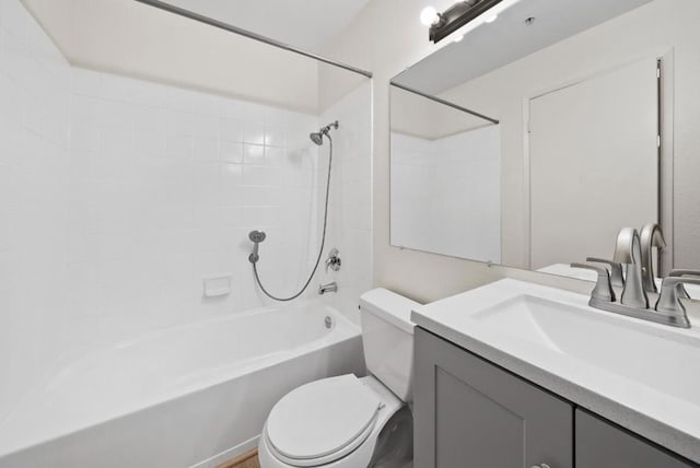 full bathroom featuring tiled shower / bath, vanity, and toilet