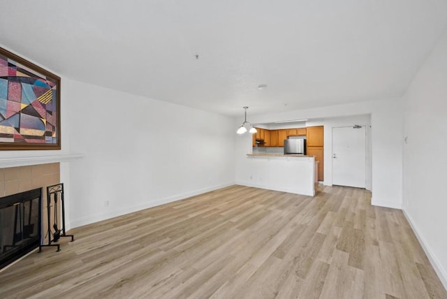 unfurnished living room with light hardwood / wood-style flooring and a fireplace