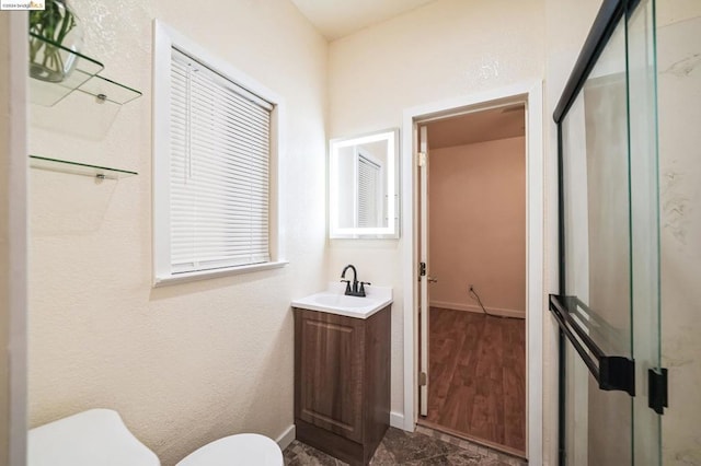 bathroom with toilet, an enclosed shower, and vanity