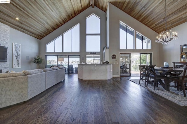 living room with high vaulted ceiling, a healthy amount of sunlight, dark wood-type flooring, and a chandelier