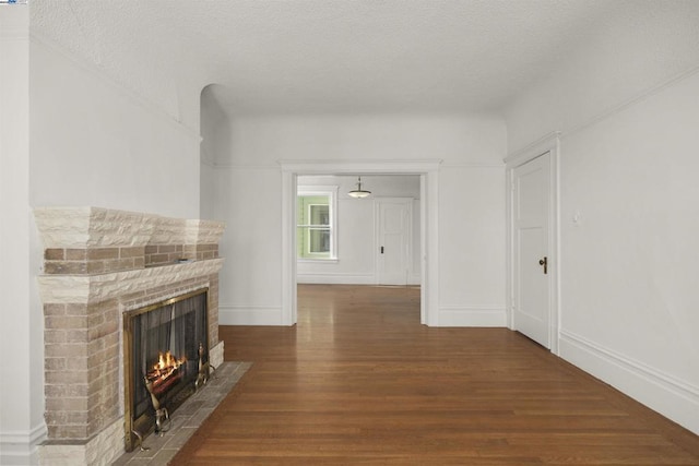 unfurnished living room featuring a textured ceiling, a fireplace, and hardwood / wood-style flooring