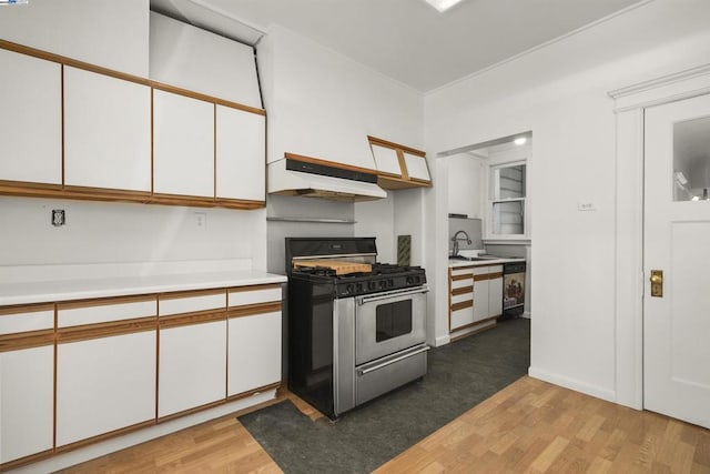 kitchen with sink, white cabinets, stainless steel range with gas cooktop, and light hardwood / wood-style flooring