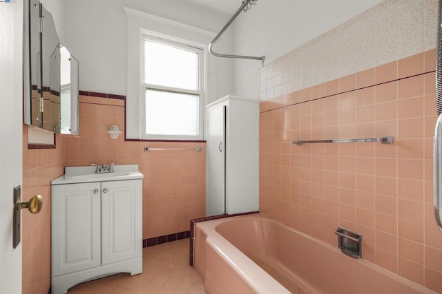 bathroom featuring tile walls, washtub / shower combination, tile patterned floors, and vanity